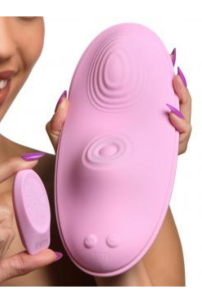 Woman holding a pink saddle-like pad with two humps for grinding. One mound is ribbed and the pulsing clit stimulator on the other mound. Small pink remote to match. Love yourself with this amazing sex toy.