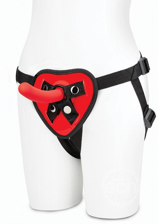 Black adjustable straps with heart-shaped piece at the front that secures a small red silicone dildo.