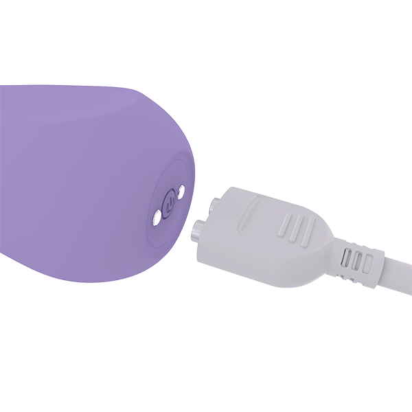 Base of pale purple vibrator showing power button and two magnetic charging pieces close to the magnetic charging cord.