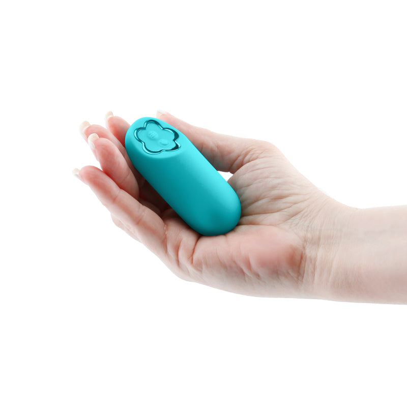 Hand holding teal mini vibrator with curve base housing the power and control buttons at the center of a metallic daisy flower outline.