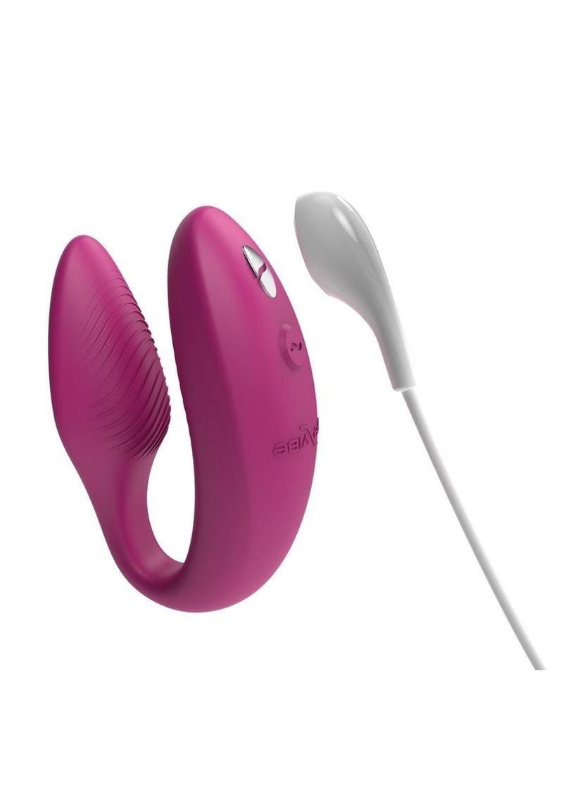 Pink u-shaped toy with controls on one side, textured on the inner part of one side for internal stimulation and bulkier opposite side for external stimulation to the clit. White charger with magnetic connection. One of the best sex toys for couples and also amazing for self-love.