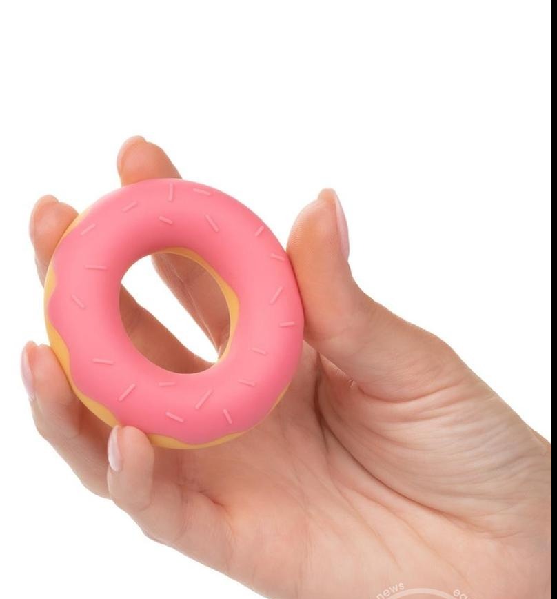 cock ring that looks like a strawberry glazed donut being held in a hand, fun adult sex toy