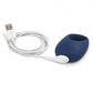 dark blue cock ring with one thick side for the vibrating motor., plugged into white USB charger.