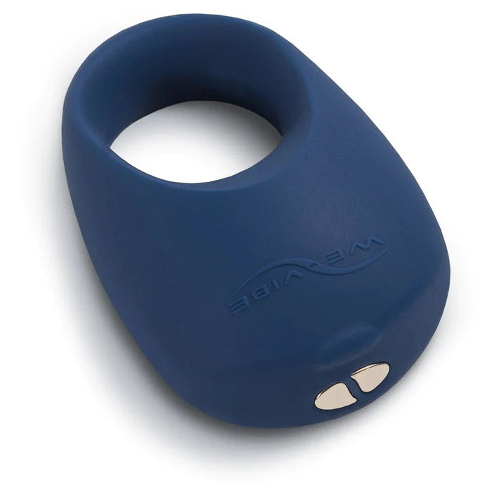dark blue cock ring with one thick side for the vibrating motor, with flat metal pieces at the bottom to connect to the charger.